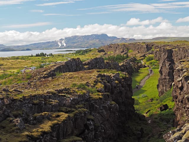 Thingvellir national park Iceland - north american - europe lithosferic rift - Mid-Atlantic Ridge with path and walking people and lake and mountain behind Thingvellir national park Iceland - north american - europe rift