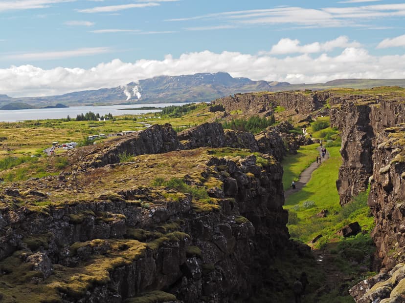 Thingvellir national park Iceland - north american - europe lithosferic rift - Mid-Atlantic Ridge with path and walking people and lake and mountain behind Thingvellir national park Iceland - north american - europe rift